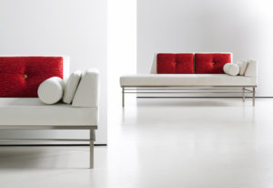 white modern low bench on chrome frame with red pillows
